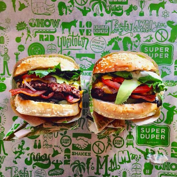 Two loaded burgers, unwrapped